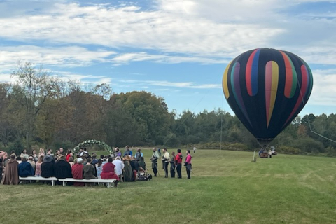 Bride and groom near a hot air balloon at a wedding hosted at Morning Glory Wedding Venue